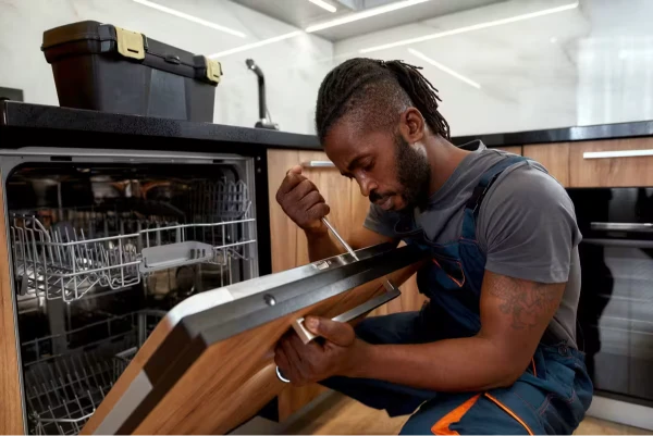dishwasher repair technician inspecting appliance in kitchen Abilene TX